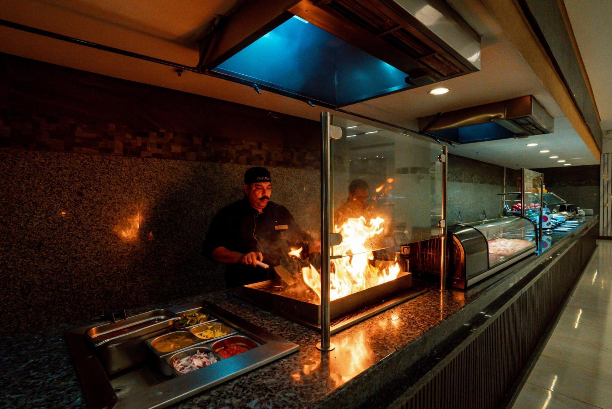 Pyramisa Beach Resort Sahl Hasheesh Hurghada Esterno foto A chef cooking with a flaming torch